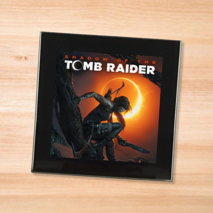 Black glass Shadow of the Tomb Raider coaster on a wood table