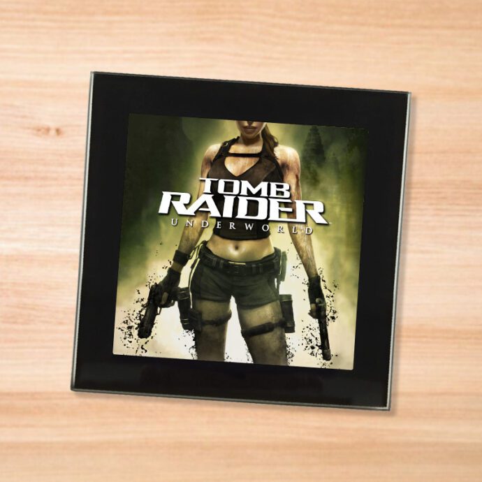 Black glass Tomb Raider Underworld coaster on a wood table