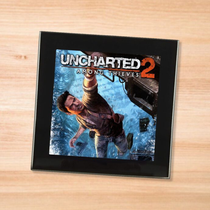 Black glass Uncharted 2 coaster on a wood table