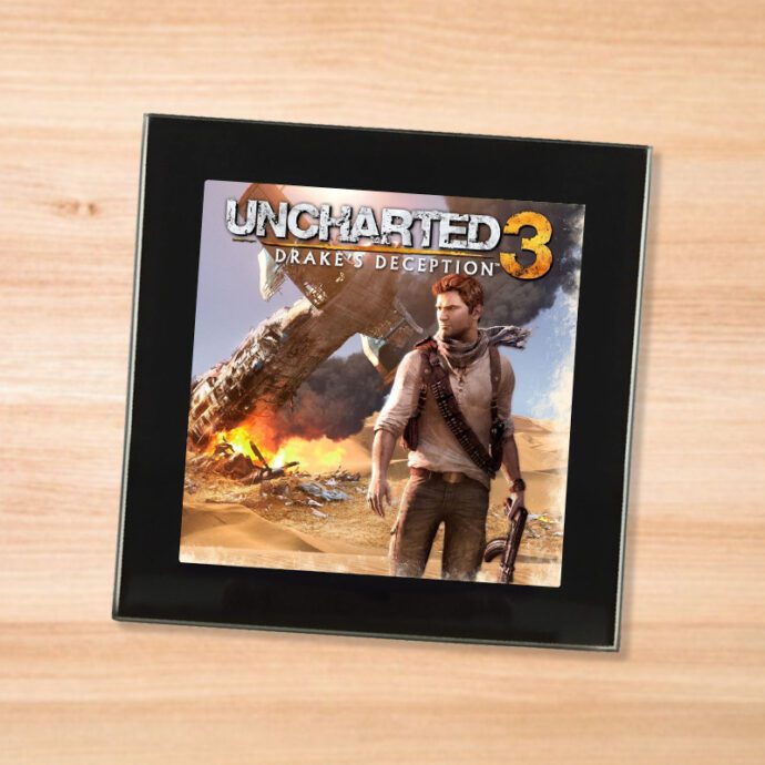 Black glass Uncharted 3 coaster on a wood table
