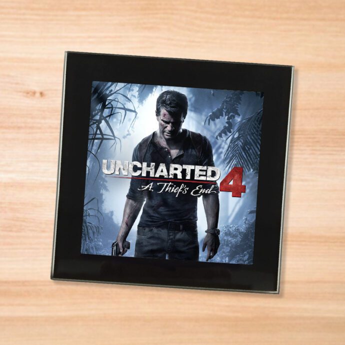 Black glass Uncharted 4 coaster on a wood table