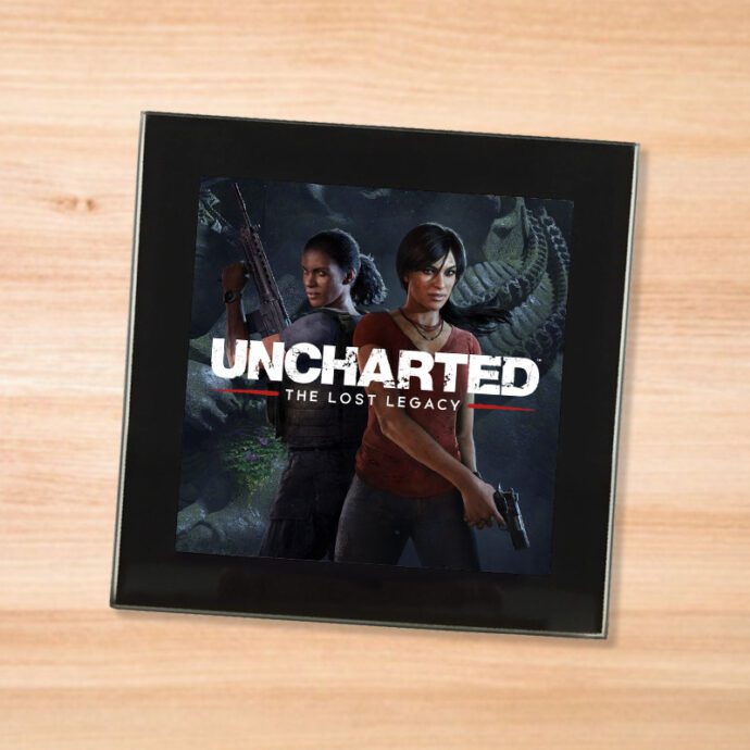 Black glass Uncharted Lost Legacy coaster on a wood table