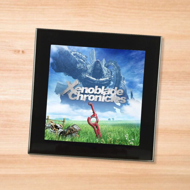 Black glass Xenoblade Chronicles coaster on a wood table