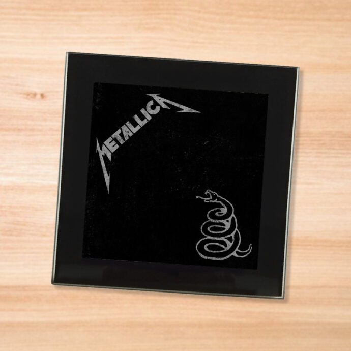 Black glass Metallica - Black Album coaster on a wood table