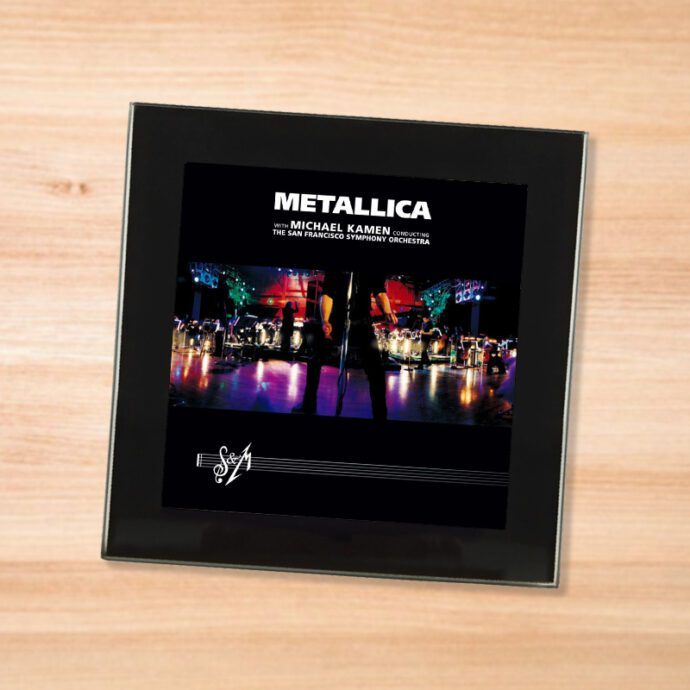 Black glass Metallica - S&M coaster on a wood table