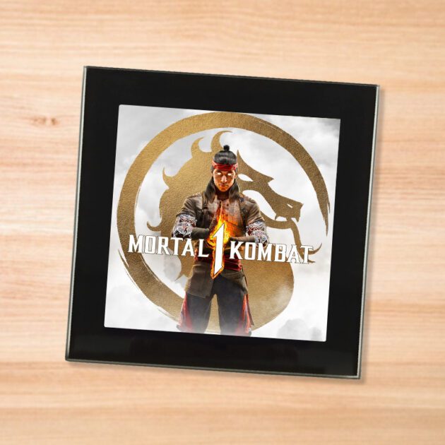 Black glass Mortal Kombat 1 coaster on a wood table
