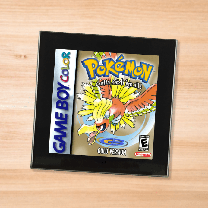 Pokemon Gold black glass coaster on a wood table