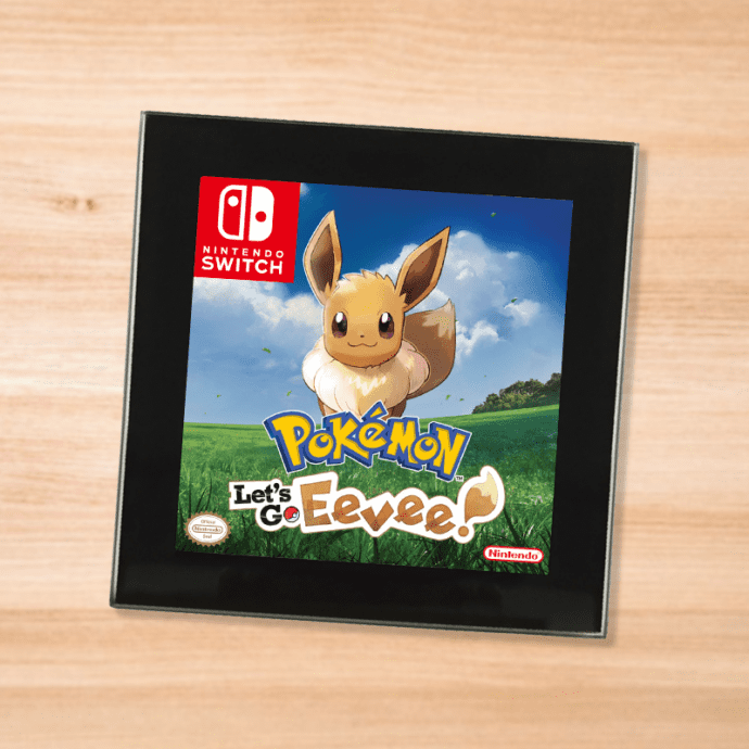 Pokemon Let's Go Eevee black glass coaster on a wood table