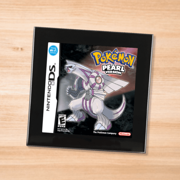 Pokemon Pearl black glass coaster on a wood table