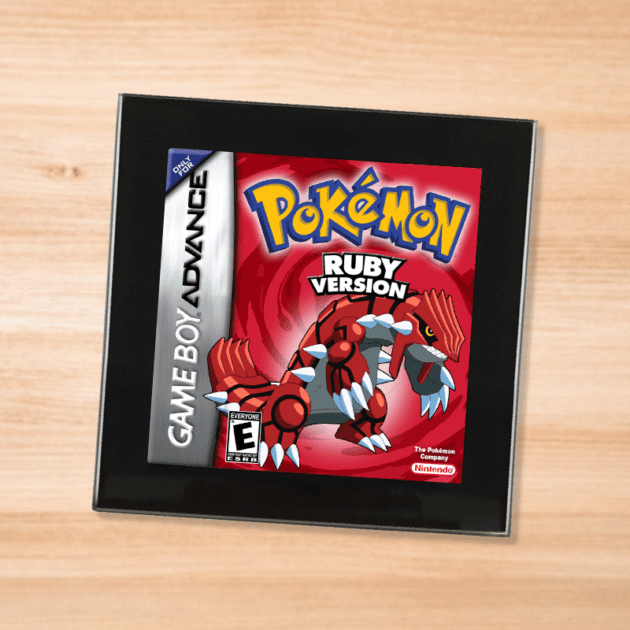 Pokemon Ruby black glass coaster on a wood table