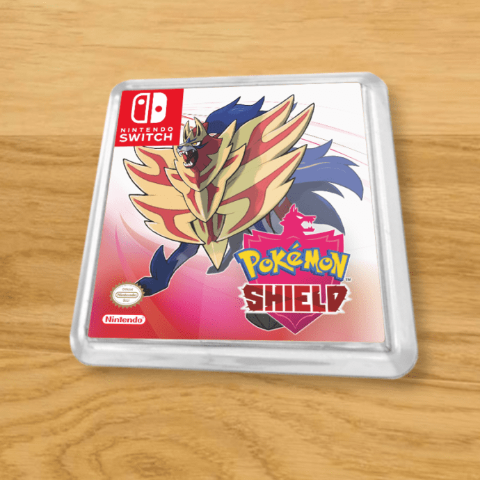 Pokemon Shield plastic coaster on a wood table