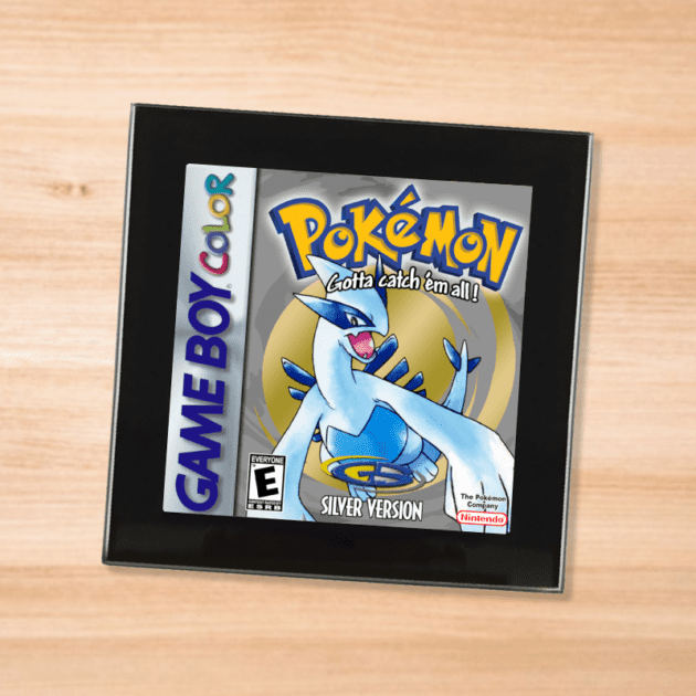 Pokemon Silver black glass coaster on a wood table